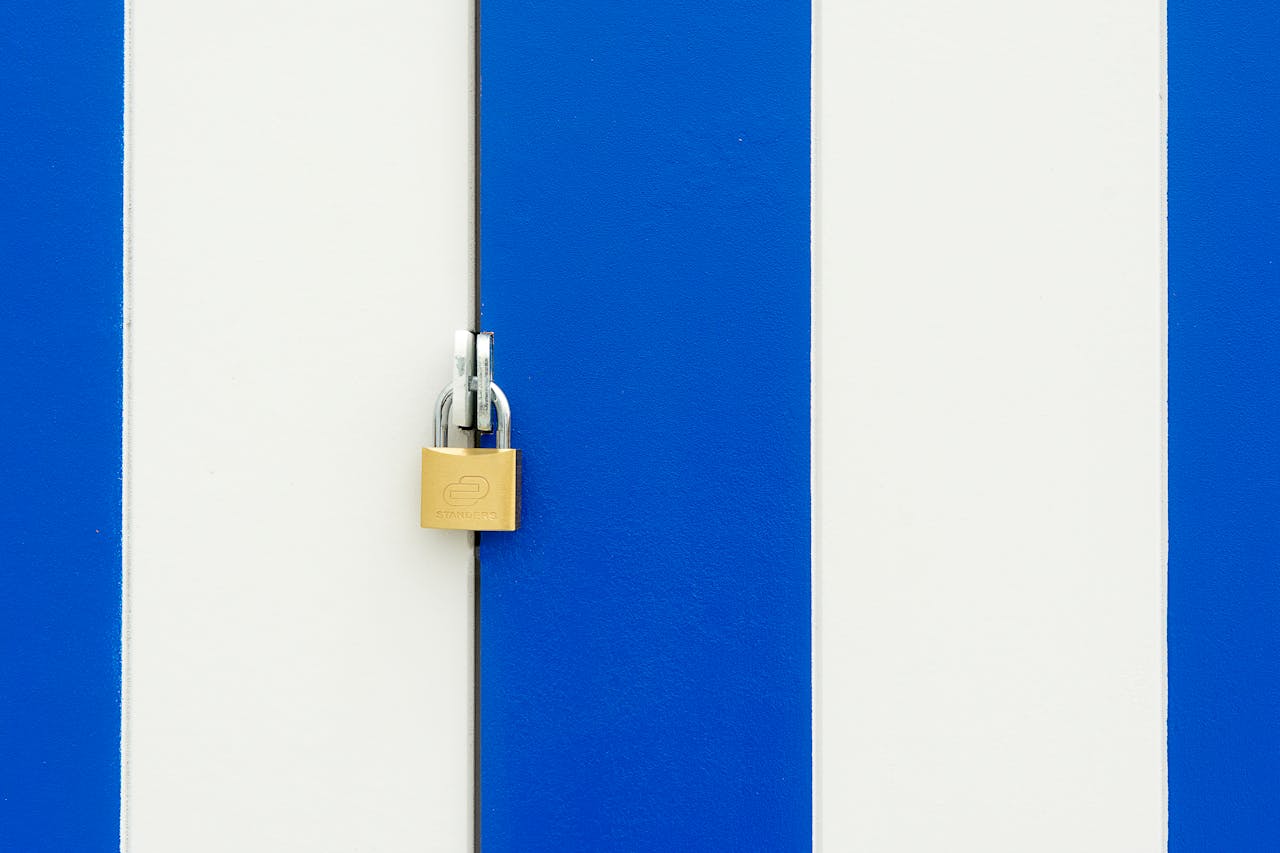 Padlock securing a blue and white striped door, symbolizing safety.